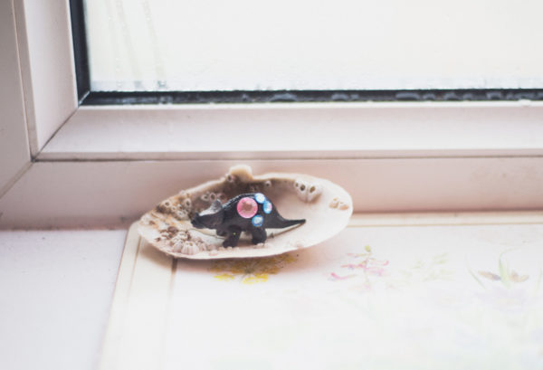 Spielzeugdinosaurier in Muschel